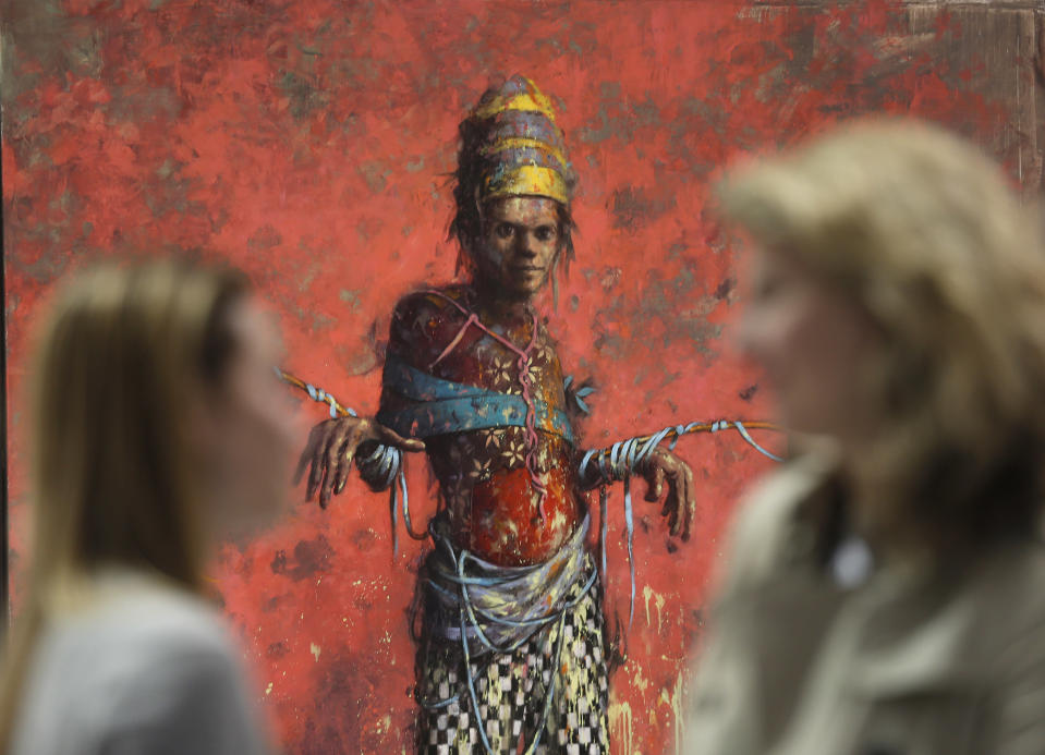 Women talk in front of a painting by Jonas Burgert from the Blain Southern gallery during a private viewing of the ART Rio-International Art Fair in Rio de Janeiro, Brazil, Wednesday, Sept. 4, 2013. Over 100 galleries from more than a dozen countries are taking part in the five-day event, which opens on Thursday to the general public. (AP Photo/Silvia Izquierdo)