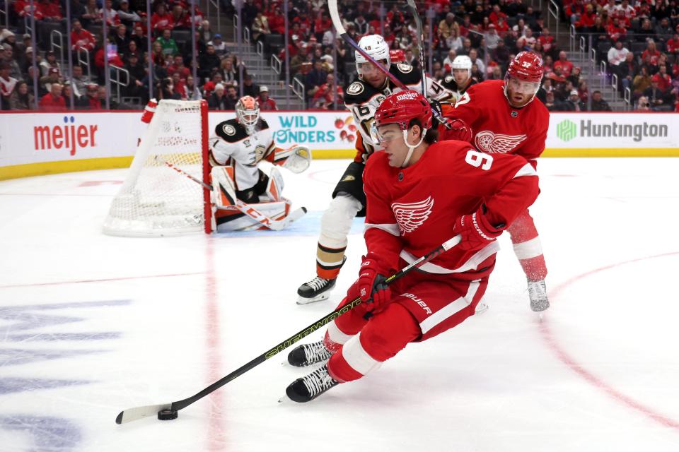 Red Wings forward Alex DeBrincat controls the puck in front of Ducks goalie Lukas Dostal during the second period of the Wings' 4-3 loss on Monday, Dec. 18, 2023, at Little Caesars Arena.