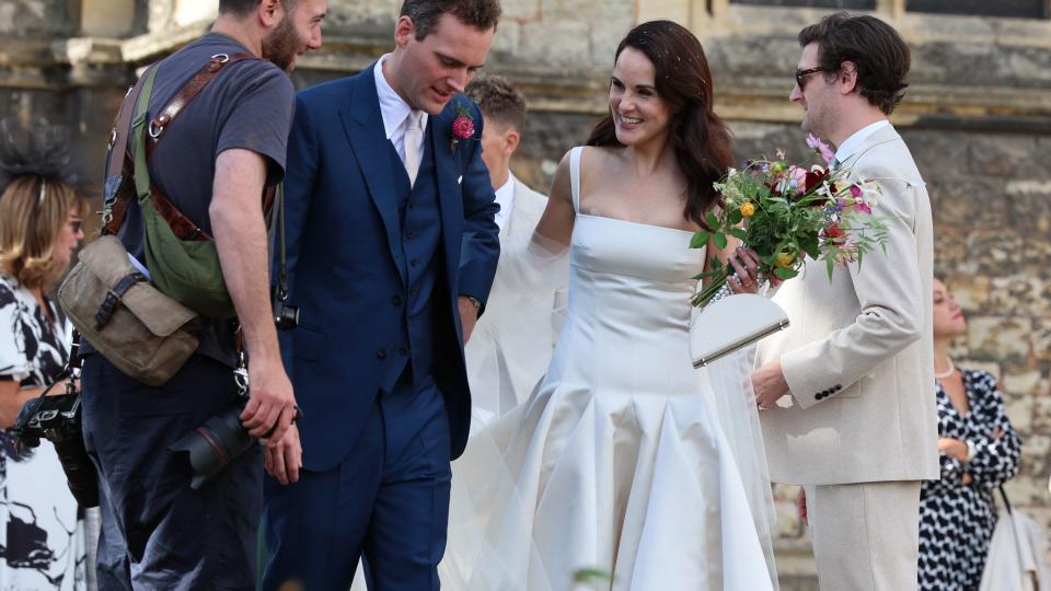 Michelle's elegant white satin Emilia Wickstead gown was complemented by an Aspinal of London Florence bag