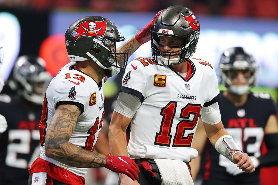 Tom Brady of the Tampa Bay Buccaneers celebrates with Mike Evans #13 after a touchdown pass to Rob Gronkowski #87 (not pictured), during the second quarter against the Atlanta Falcons at Mercedes-Benz Stadium on December 05, 2021 in Atlanta, Georgia.