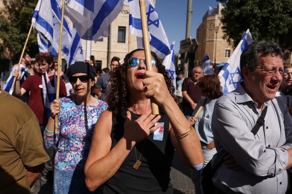 People hold Israeli flags in Jerusalem, marking one-month since Hamas’s attacks which left 1,400 dead (REUTERS)
