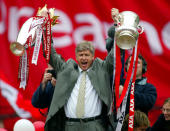 FILE PHOTO: Soccer Football - Arsenal FA Cup and League Championship Trophy Parade - Britain - May 12, 2002 Arsenal Manager Arsene Wenger celebrates by holding aloft the FA Cup and FA Barclaycard Championship trophy Action Images via Reuters/Alex Morton/File Photo