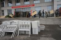 Workers wearing face masks move bed parts into a makeshift hospital which has been converted from an office building to treat patients with the novel coronavirus disease (COVID-19) in Suifenhe, a city of Heilongjiang province on the border with Russia