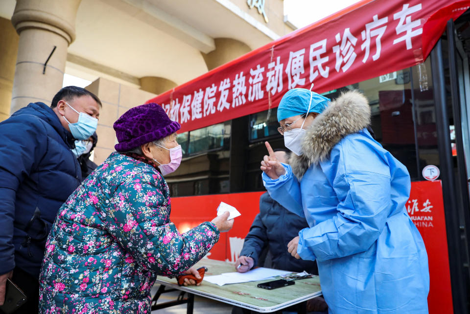 A medical worker provides instructions to a resident at a mobile fever clinic converted from a bus amid the coronavirus disease (COVID-19) outbreak, in Huaian, Jiangsu province, China December 25, 2022. cnsphoto via REUTERS   ATTENTION EDITORS - THIS IMAGE WAS PROVIDED BY A THIRD PARTY. CHINA OUT.