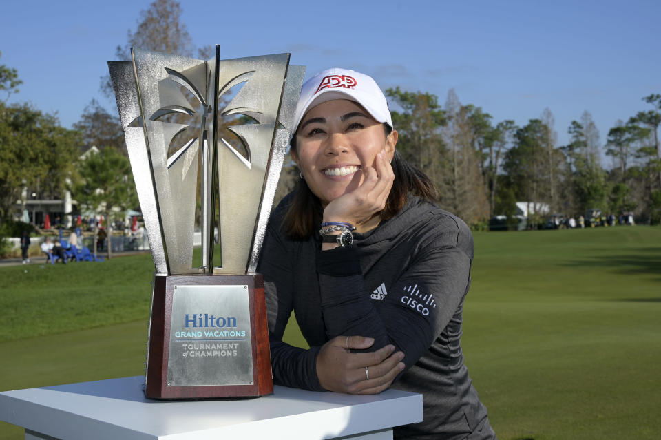 Danielle Kang poses next to the championship trophy on the 18th green after winning the Tournament of Champions LPGA golf tournament, Sunday, Jan. 23, 2022, in Orlando, Fla. (AP Photo/Phelan M. Ebenhack)