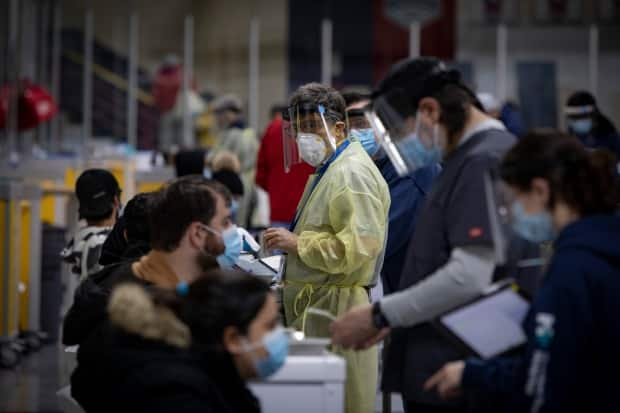 Health-care workers administer the Pfizer-BioNtech COVID-19 vaccine to residents of hot spots in Toronto.