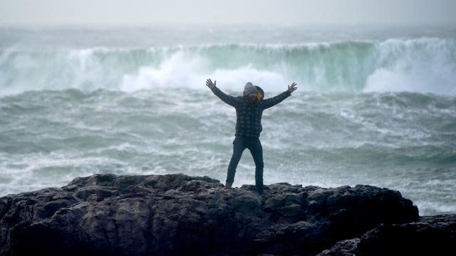 A tourist poses for a photograph on the Burrinn, near the lighthouse of Kendubh, Co.  Clare