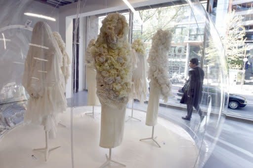 A woman looks at creations by Japanese designer Rei Kawakubo for Comme des Garcons fashion house exhibited April 11, 2012 in Paris