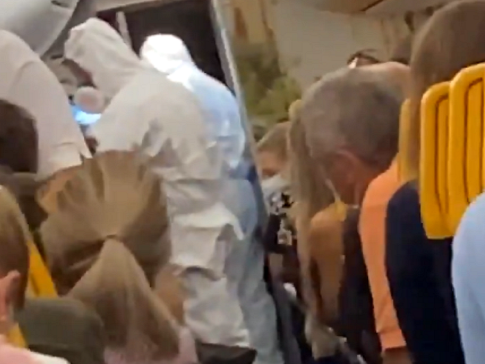 Still image taken from video posted on Twitter by @FionnMurphy10 of officials in hazmat suits removing two passengers from a Ryanair flight at Stansted Airport after one of them tested positive for coronavirus: Twitter/@FionnMurphy10