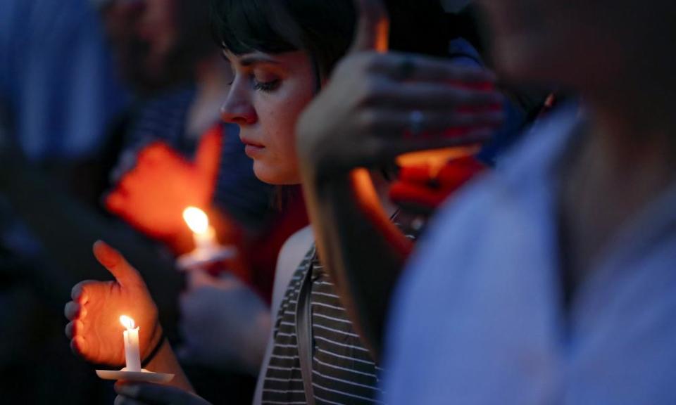 Mourners bow their heads in prayer as they gather for a vigil at the scene of a mass shooting in Dayton, Ohio.