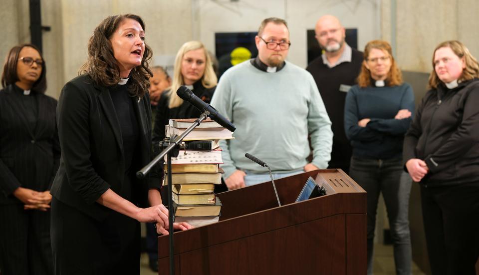 Local ministers deliver Bibles to the podium and then stand in support of the Rev. Lori Walke as she speaks on Tuesday at the Oklahoma City Council meeting.