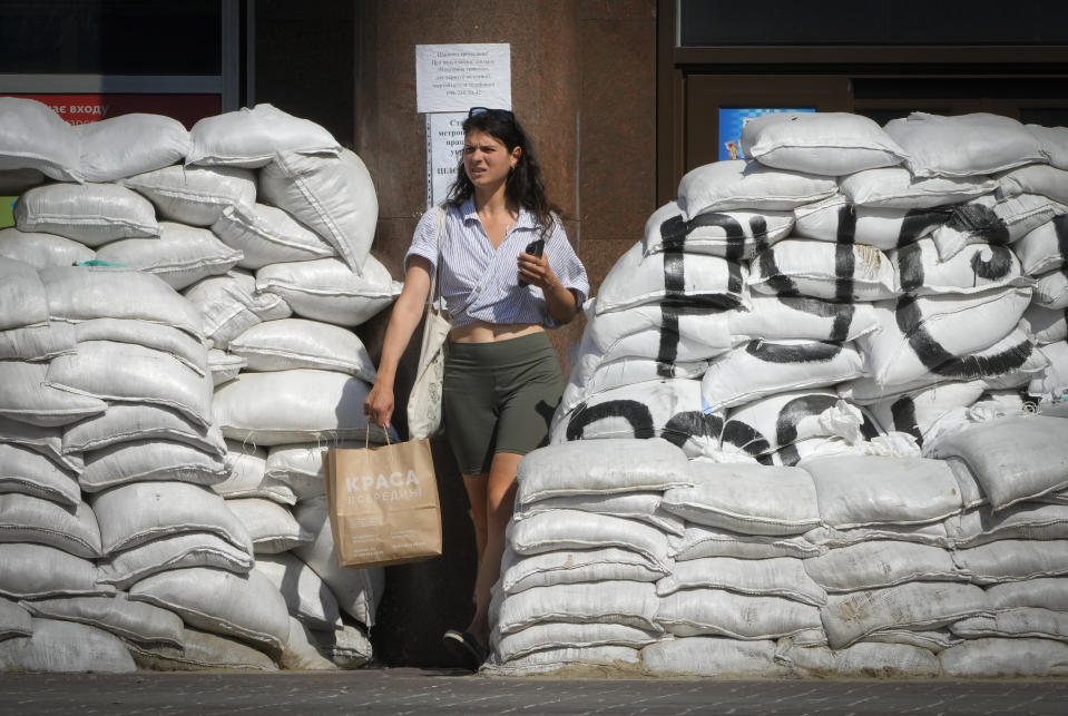 A woman passes by sandbags that were set to protect against Russian shelling in central Kyiv, Ukraine, Tuesday, June 7, 2022. (AP Photo/Efrem Lukatsky)