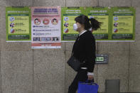 A woman wearing a face mask passes by posters about precautions against new coronavirus at a subway station in Seoul, South Korea, Saturday, March 21, 2020. For most people, the new coronavirus causes only mild or moderate symptoms, such as fever and cough. For some, especially older adults and people with existing health problems, it can cause more severe illness, including pneumonia. (AP Photo/Ahn Young-joon)