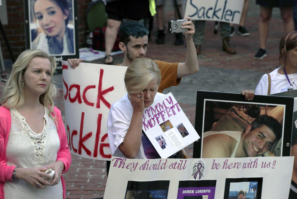 Protesters, including Carol Lorento, center, gather outside a courthouse on Friday, Aug. 2, 2019, in Boston, where a judge was to hear arguments in Massachusetts' lawsuit against Purdue Pharma over its role in the national drug epidemic. Organizers said they wanted to continue to put pressure on the Connecticut pharmaceutical company and the Sackler family that owns it. (AP Photo/Charles Krupa)