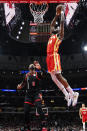 Atlanta Hawks forward Bruno Fernando, right, goes up for a dunk as Chicago Bulls center Andre Drummond looks on during the first half of an NBA basketball game in Chicago, Monday, April 1, 2024. (AP Photo/Nam Y. Huh)