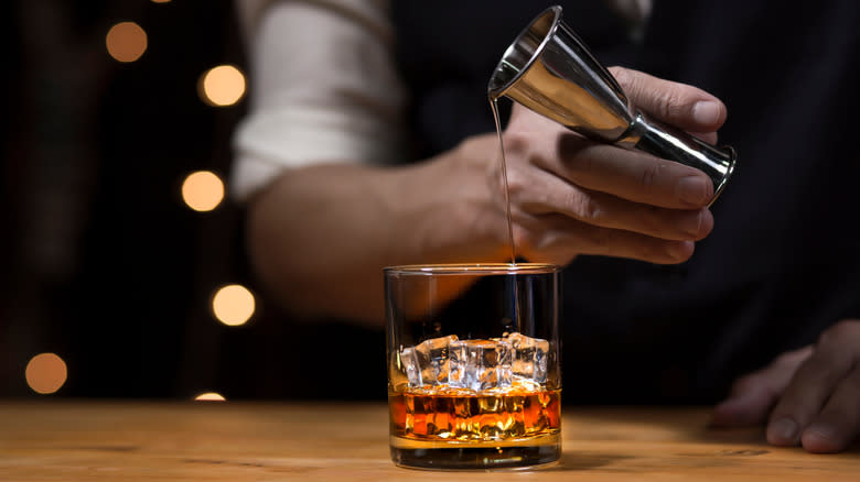 Bartender pouring whiskey cocktail