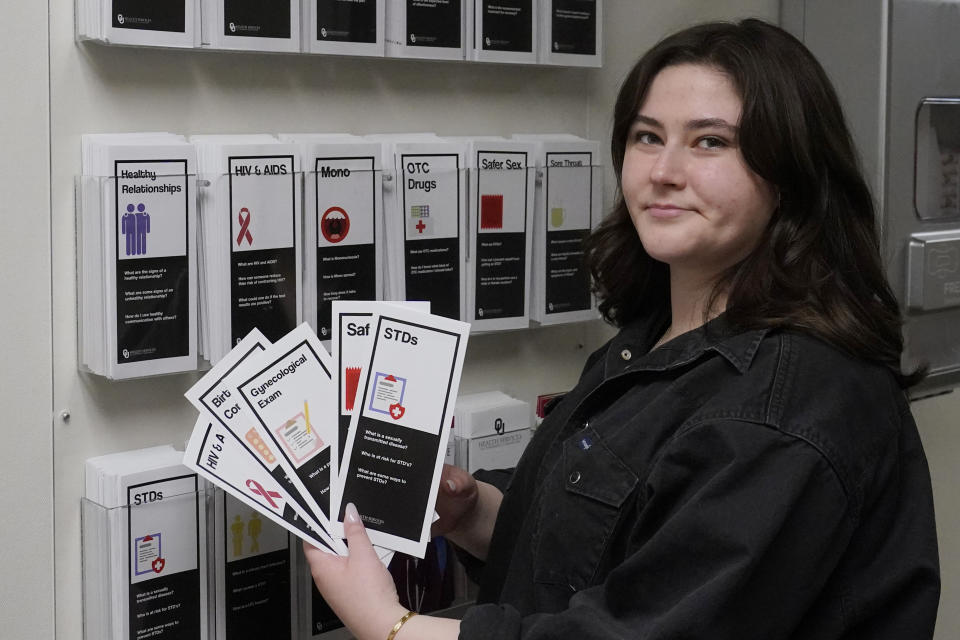 Abby Tow, a Sexual Health Peer Educator at the University of Oklahoma, displays some of the sexual health pamphlets available at the health center on campus, Wednesday, May 10, 2023, in Norman, Okla. Tow said she wonders if helicopter parenting has played a role in what she calls the "baby-fication of our generation". (AP Photo/Sue Ogrocki)