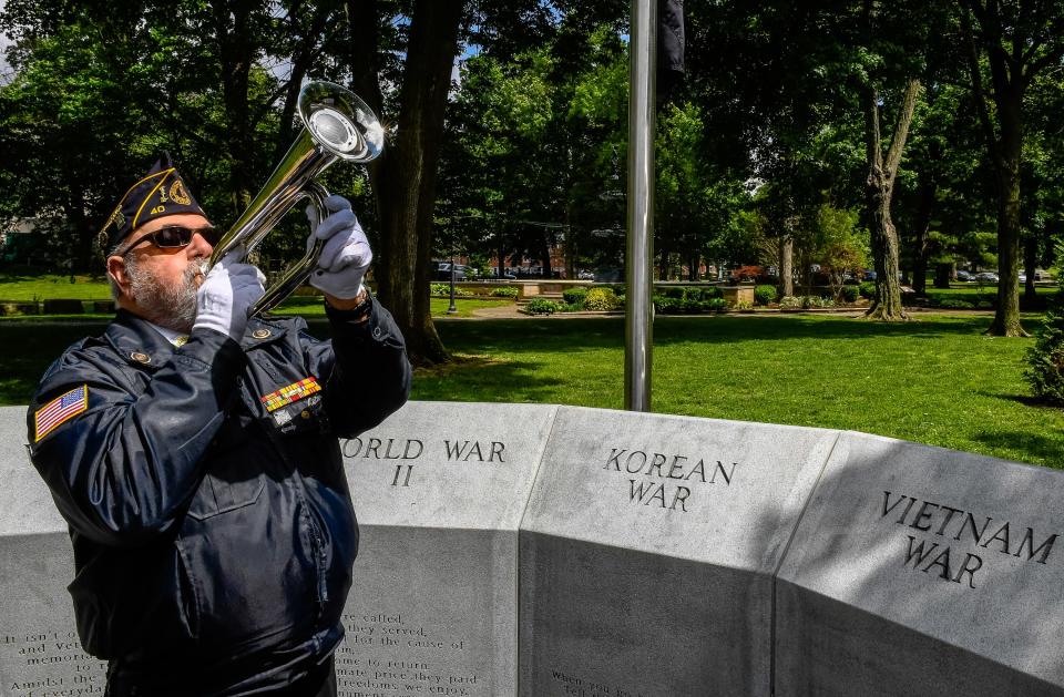 Standing in the Central Park War Memorial, Sappy Gastenveld, bugler with the American Legion Worsham Post 40, plays “Taps” following the unveiling of a temporary sign in Central Park acknowledging the decades-long work of the American Legion in creating the annual Memorial Day cross display. Due to the pandemic, organizers decided not to erect the more than 5,300 crosses representing deceased Henderson County veterans Friday, May 8, 2020.