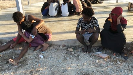 Migrants are seen rescued by Libyan coast guard after their wooden boat capsized off the coast of Komas, a town east of the capital Tripoli