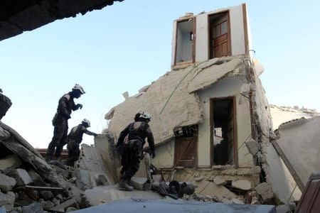 Civil Defence members inspect a damaged site after an airstrike in the besieged rebel-held al-Qaterji neighbourhood of Aleppo, Syria October 14, 2016. REUTERS/Abdalrhman Ismail