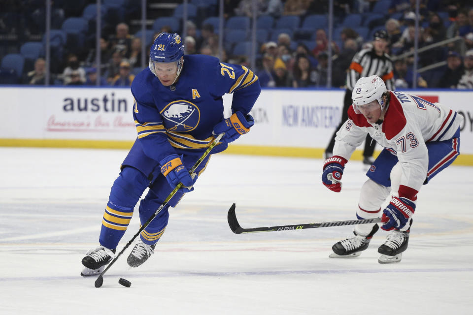 Buffalo Sabres right wing Kyle Okposo (21) skates with the puck by Montreal Canadiens right wing Tyler Toffoli (73) during the second period of an NHL hockey game on Friday, Nov. 26, 2021, in Buffalo, N.Y. (AP Photo/Joshua Bessex)