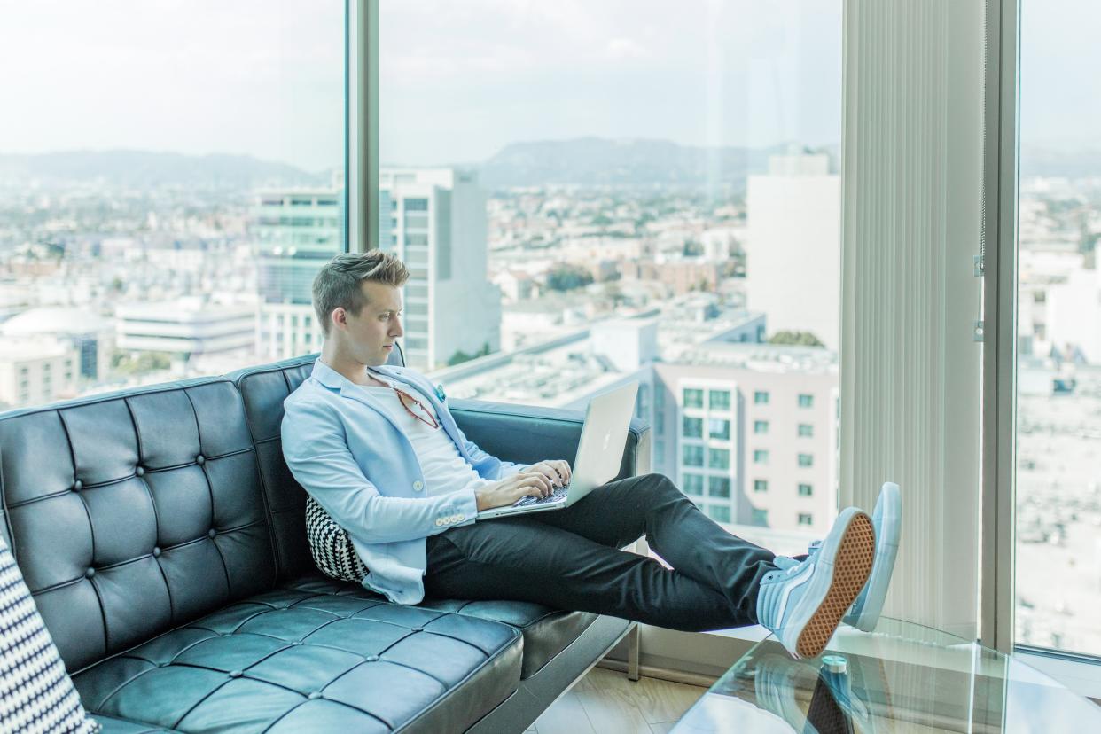 Man on leather couch with laptop