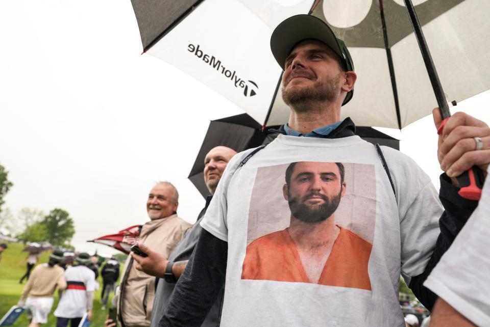 Spectator Cole Turner of New York wore a T-shirt that had professional golfer and the No.1-ranked Scottie Scheffler's Louisville Metro Corrections' mug shot at the 2024 PGA Championship second round Friday at Valhalla Golf Course in Louisville, Kentucky May 17, 2024. Scheffler was arrested early Friday morning on charges of second-degree assault, third-degree criminal mischief, reckless driving and disregarding signals from an officer directing traffic, according to jail records and his arrest citation. Scheffler made it to his tee time.