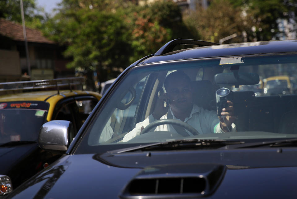 In this April 3, 2014 photo, Uber driver Dinish Karamsesula, whose employer partnered with the company in Mumbai, drives his black SUV in Mumbai, India. Riding on its startup success and flush with fresh capital, taxi-hailing smartphone app Uber is making a big push into Asia. The company has in the last year started operating in 18 cities in Asia and the South Pacific including Seoul, Shanghai, Bangkok, Hong Kong and five Indian cities. (AP Photo/Rafiq Maqbool)