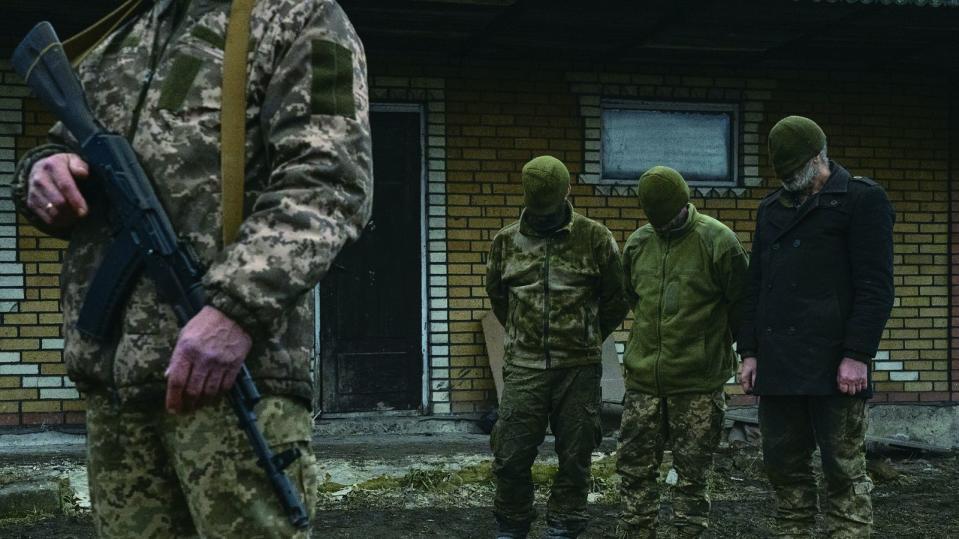 烏克蘭，克拉馬托爾斯克，2023年12月23日。3名被俘的俄羅斯軍人，被判定為「戰俘」身分，據稱他們無意戰鬥，隨著一支來自西伯利亞的突擊旅被派至阿夫迪夫卡附近，幾天之後便被俘虜。一名烏克蘭士兵，手握AK步槍，嚴密看守他們。