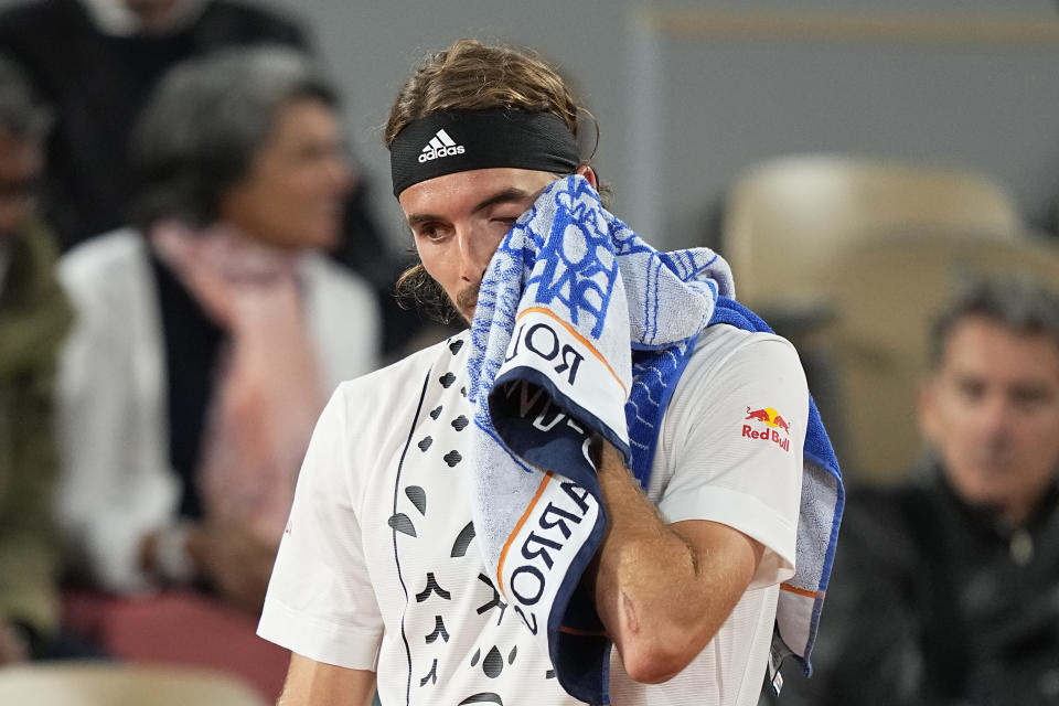 Greece's Stefanos Tsitsipas wipes his face as he plays Italy's Lorenzo Musetti during their first round match of the French Open tennis tournament at the Roland Garros stadium Tuesday, May 24, 2022 in Paris. (AP Photo/Michel Euler)