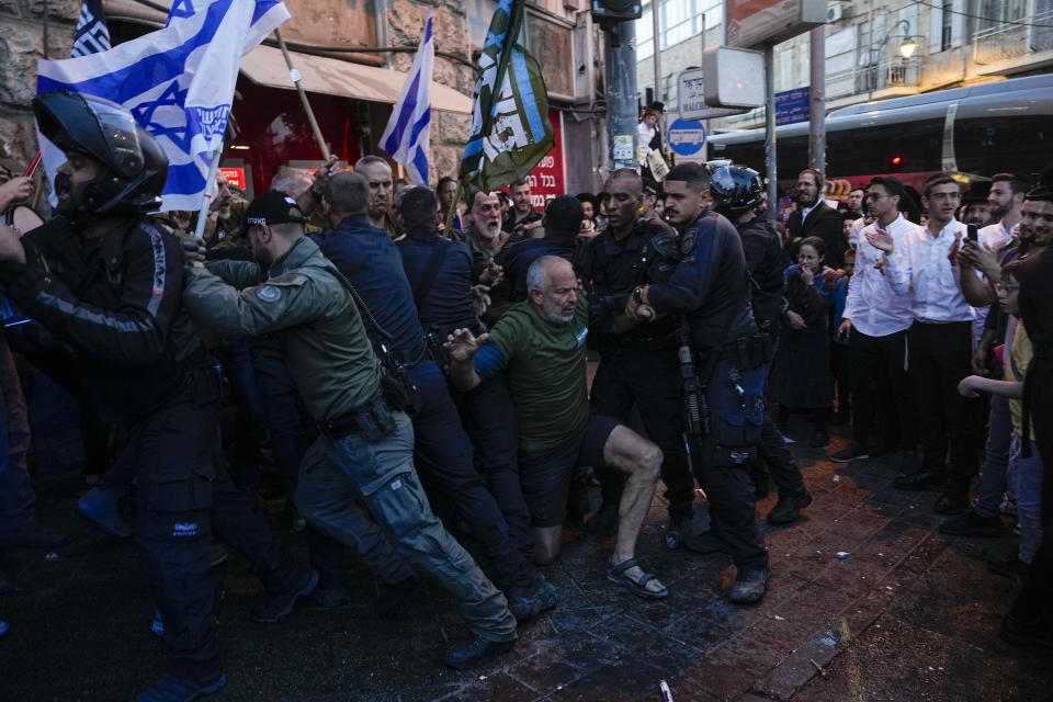 Police push a way members of Brothers and Sisters in Arms during a protest against Israel's exemptions for ultra-Orthodox Jews from mandatory military service, in Mea Shearim ultra-Orthodox neighborhood in Jerusalem, Sunday, March 31, 2024. (AP Photo/Ohad Zwigenberg)