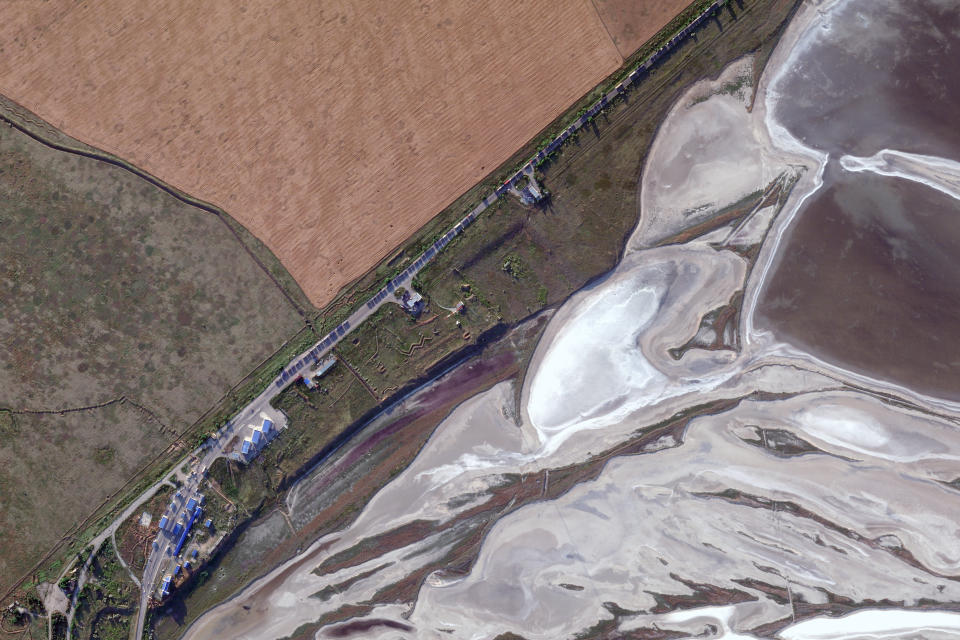 This Planet Labs satellite image shows some of the trucks headed to Crimea backed up for more than a mile (more than 1.6 kilometers) at a border checkpoint at Chonhar, Ukraine, on June 17, 2022. An investigation by The Associated Press shows a Russian-run smuggling operation has been transporting grain from occupied regions of Ukraine by train and truck to ports in Crimea, where it is shipped to buyers in the Middle East. (Planet Labs via AP)