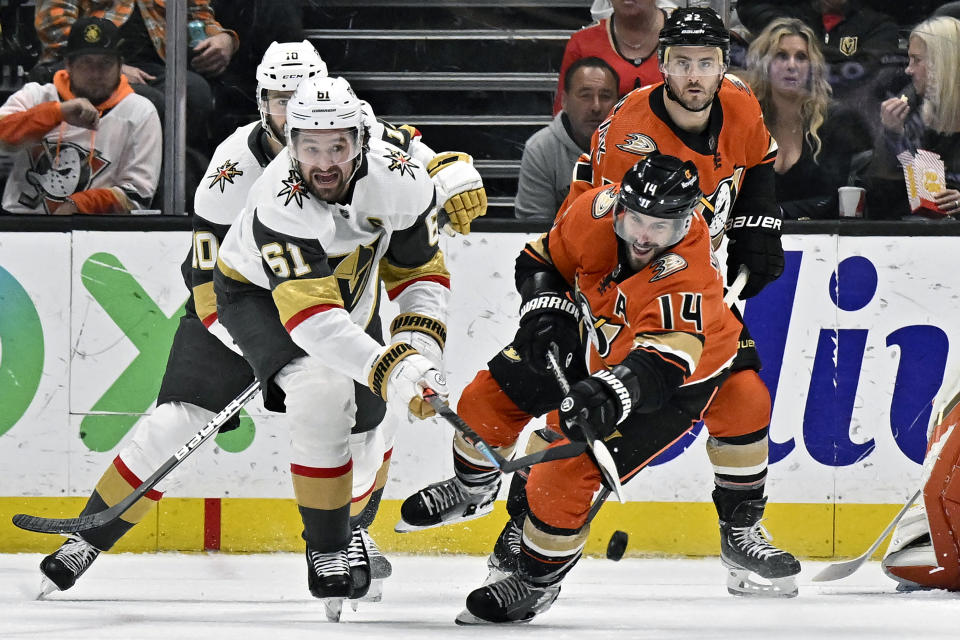 Anaheim Ducks center Adam Henrique, right, clears the puck away from Vegas Golden Knights right wing Mark Stone, left, during the first period of an NHL hockey game in Anaheim, Calif., Wednesday, Dec. 28, 2022. (AP Photo/Alex Gallardo)