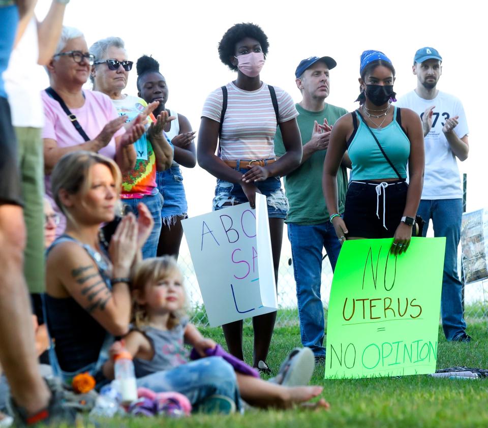 Cousins Taina Paige of Bear, center, and Gillian Paige of Newark, in black mask, stand with other abortion rights protesters as they demonstrate in Battery Park in Newe Castle following the Supreme Court's striking down of federal protection for abortion Friday, June 24, 2022.