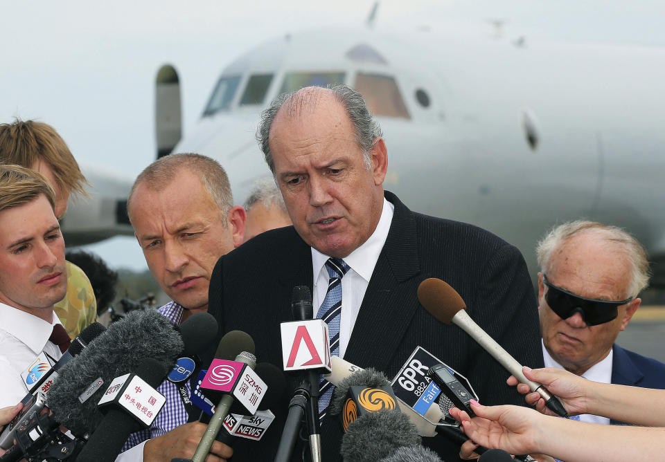 FILE - In this March 25, 2014 file photo, Australia's Defense Minister David Johnston, center, speaks to the media about developments in the search for the missing Malaysia Airlines Flight 370 in Perth, Australia. Not one object has been recovered from the missing airliner that Malaysian officials are now convinced plunged into the southern Indian Ocean 17 days ago. Australian Defense Minister Johnston said, “The turning point for us, I think, will be when we pull some piece of debris from the surface of the ocean and positively identify it as being part of the aircraft.” (AP Photo/Rob Griffith, File)