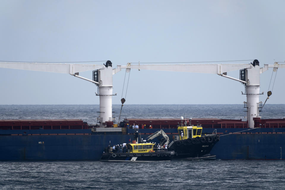 Russian, Ukrainian, Turkish and U.N. officials arrive to the cargo ship Razoni for inspection while it is anchored at the entrance of the Bosphorus Strait in Istanbul, Turkey, Wednesday, Aug. 3, 2022. The Sierra Leone-flagged Razoni, loaded up with 26,000 tons of corn, is the first cargo ship to leave Ukraine since the Russian invasion, and set sail from Odesa Monday, August 1, 2022. Its final destination is Lebanon. (AP Photo/Khalil Hamra)