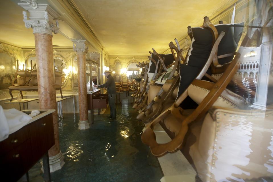 A man stands in his shop flooded with water, in Venice, Wednesday, Nov. 13, 2019. The high-water mark hit 187 centimeters (74 inches) late Tuesday, Nov. 12, 2019, meaning more than 85% of the city was flooded. The highest level ever recorded was 194 centimeters (76 inches) during infamous flooding in 1966. (AP Photo/Luca Bruno)