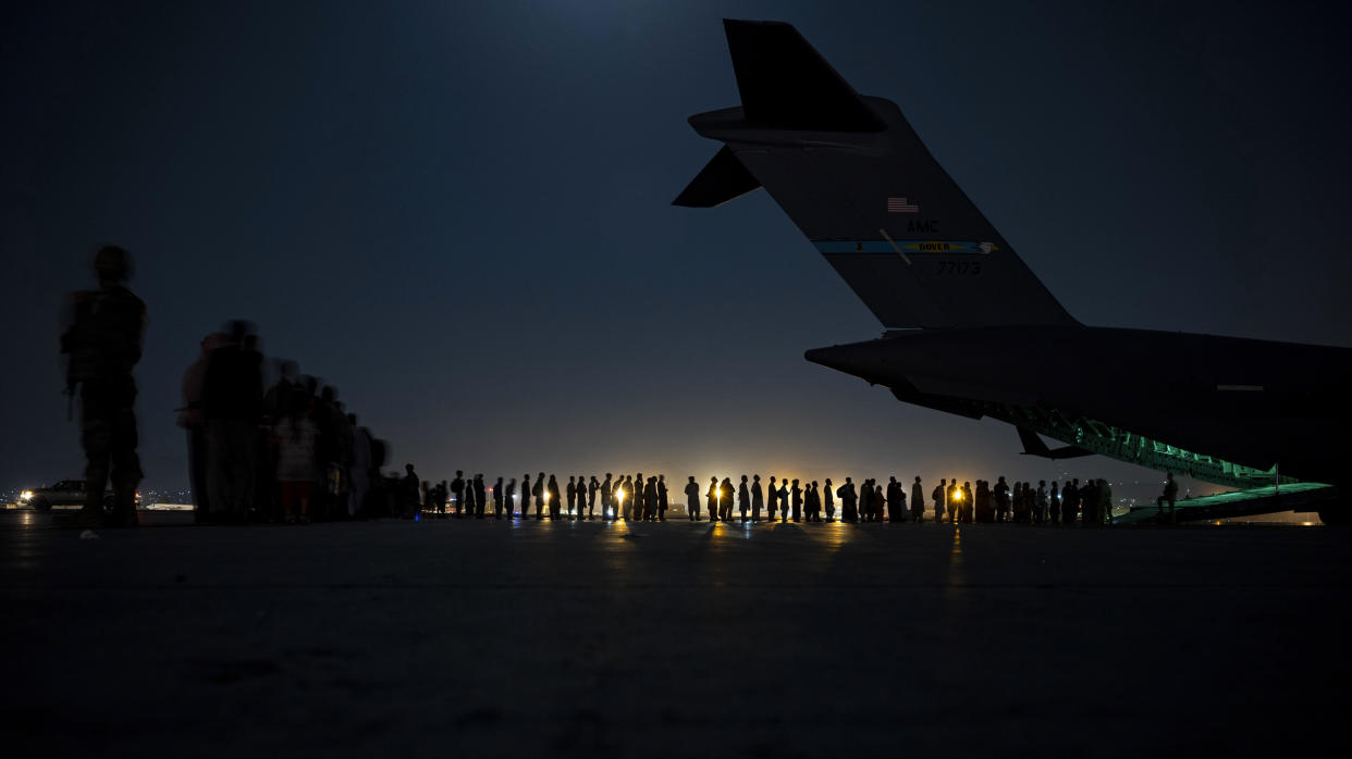 FILE - In this Aug. 21, 2021, file image provided by the U.S. Air Force, U.S. Air Force aircrew, assigned to the 816th Expeditionary Airlift Squadron, prepare to load qualified evacuees aboard a U.S. Air Force C-17 Globemaster III aircraft in support of the Afghanistan evacuation at Hamid Karzai International Airport, Kabul, Afghanistan. (Senior Airman Taylor Crul/U.S. Air Force via AP, File)