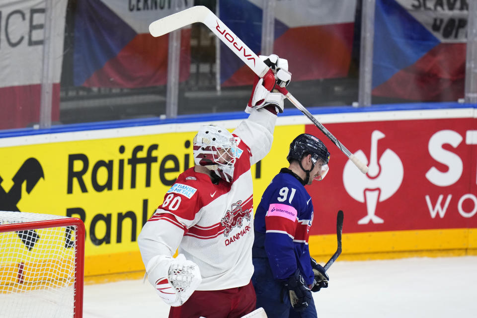 Britain's Ben Lake, right, skates past Denmark's goalkeeper Frederik Dichow who celebrates after the preliminary round match between Great Britain and Denmark at the Ice Hockey World Championships in Prague, Czech Republic, Friday, May 17, 2024. (AP Photo/Petr David Josek)