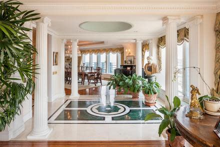 Guests are greeted by a gracious, formal entry foyer, adorned with inlaid marble floors and elegant columns, on the 73rd floor. (Photo by Evan Joseph/Prudential Douglas Elliman)