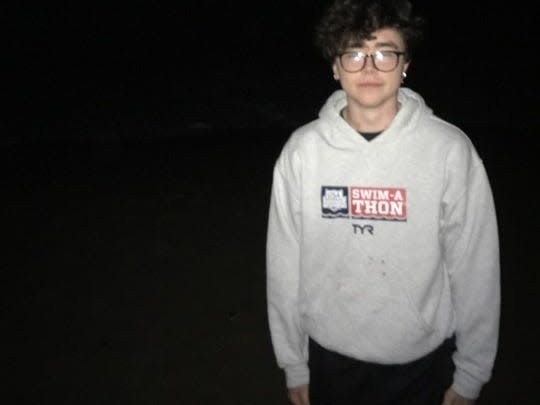 Sebastian Cahill standing in front of the ocean but it's late at night.