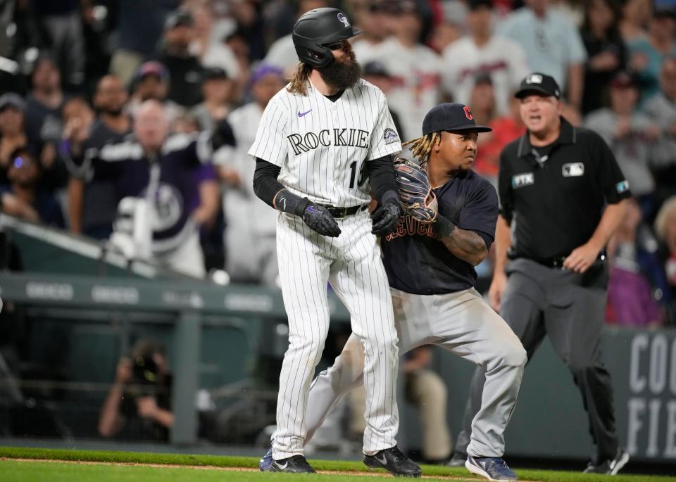 Guardians third baseman Jose Ramirez tags out Colorado Rockies runner Charlie Blackmon, left, who was caught in a rundown between third base and home plate during the 10th inning of Tuesday night's game in Denver. The Guardians won 4-3 in 10 innings. [David Zalubowski/Associated Press]