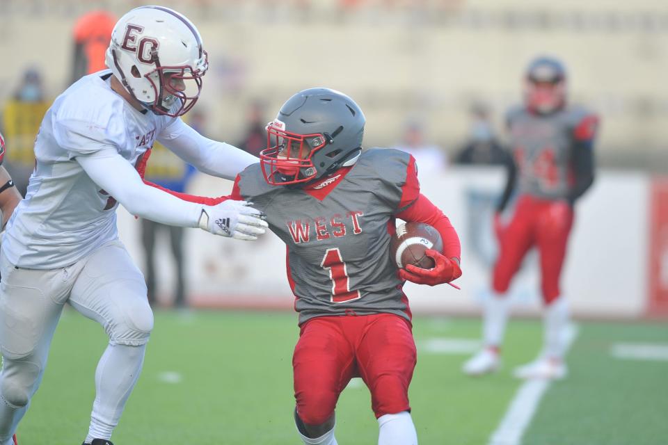 Cranston West's Marcus Chung uses a stiff arm against East Greenwich's Andrew Plympton during this first-quarter run on Friday.