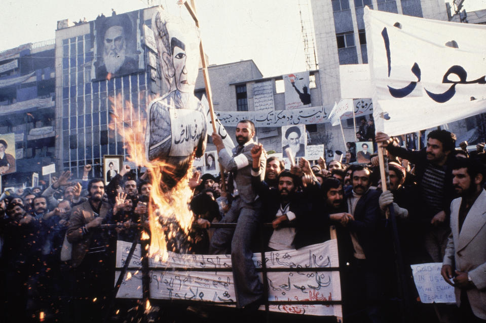 FILE - In an undated photo from 1979, protestors burn an effigy of Shah Mohammad Reza Pahlavi during a demonstration in front of the U.S. Embassy in Tehran, Iran. Forty years ago, Iran's ruling shah left his nation for the last time and an Islamic Revolution overthrew the vestiges of his caretaker government. The effects of the 1979 revolution, including the takeover of the U.S. Embassy in Tehran and ensuing hostage crisis, reverberate through decades of tense relations between Iran and America. (AP Photo, File)
