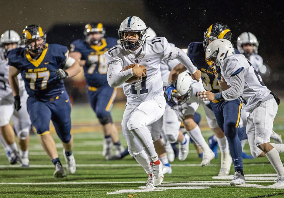 McDowell's Christian Santiago (11) rushes for a touchdown during the first quarter of a PIAA Class 6A quarterfinal football game on Friday at Mt. Lebanon High School in Pittsburgh. The Trojans lost to the Blue Devils 47-14.