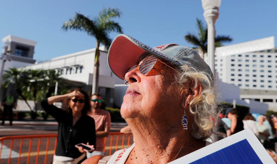 Carolyn P. Smith of Fort Myers Beach. a supporter of form President Donald Trump, awaits for his arrival Friday in downtown Fort Myers. Trump spoke at  the Lee County Republican Party's 2023 Lincoln Reagan Dinner. a sold-out fundraiser at the Caloosa Sound Convention Center. Supporters and protestors gathered outside before and during the event.