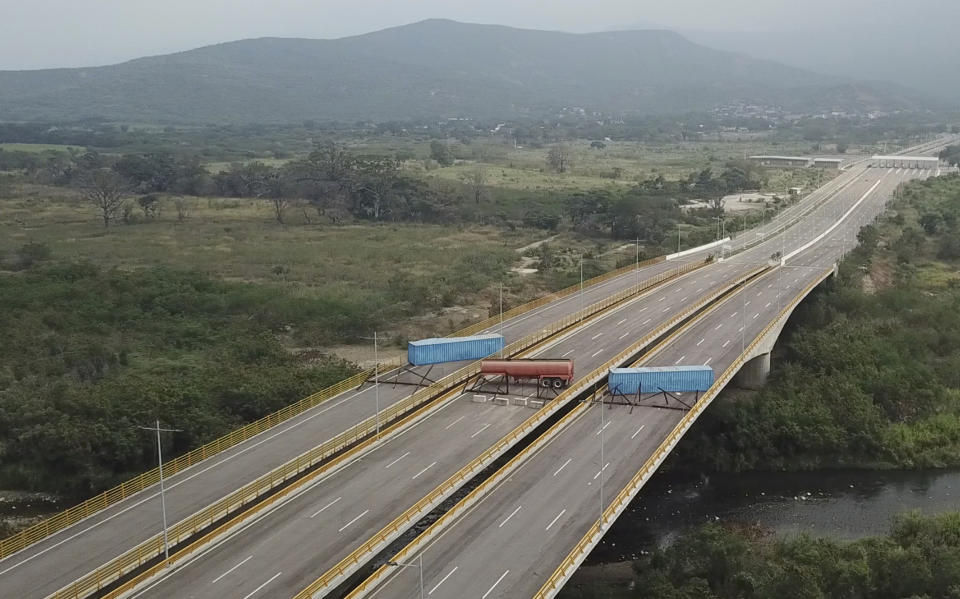 This Feb. 6, 2019 file image taken from video, shows a fuel tanker, cargo trailers and makeshift fencing, blocking the Tienditas International Bridge in an attempt to stop humanitarian aid entering from Colombia, as seen from the outskirts of Cucuta, on Colombia's border with Venezuela. (AP Photo, File)