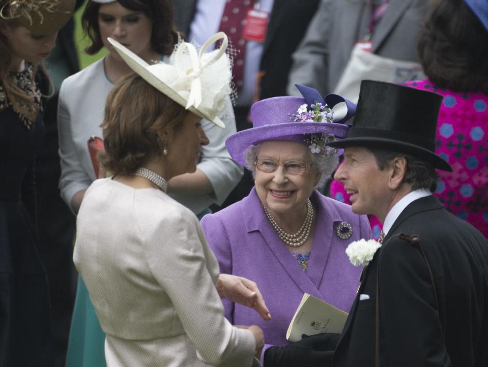 Britain's Queen Elizabeth II smiles as she talks to her racing manager John Warren, right, as she waits in the parade ring for her horse Estimate who will run in the Gold Cup horse race on the third day traditionally known as Ladies Day of the Royal Ascot horse race meeting in Ascot, England, Thursday, June 20, 2013. (AP Photo/Alastair Grant)