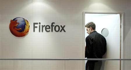 A man is seen next to a Firefox logo at a Mozilla stand during the Mobile World Congress in Barcelona, February 28, 2013. REUTERS/Albert Gea