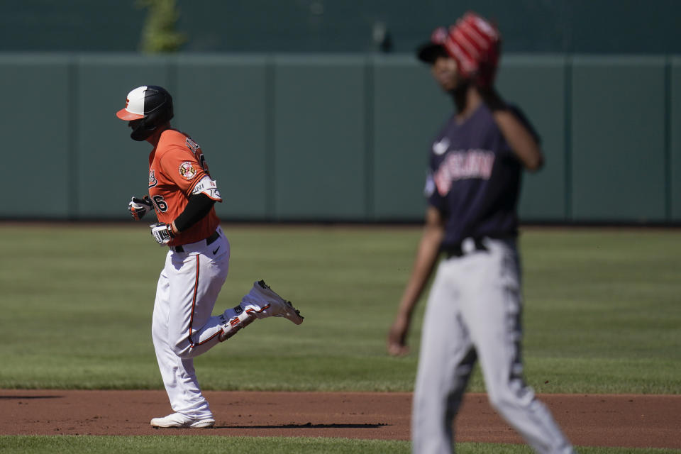 Baltimore Orioles' Trey Mancini, left, runs the bases as Cleveland Guardians starting pitcher Triston McKenzie, right, waits for a new ball after Mancini hit a solo home run off him during the first inning of a baseball game, Saturday, June 4, 2022, in Baltimore. (AP Photo/Julio Cortez)